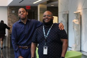 A student standing with his arm around his counselor's shoulders.