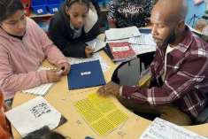 Teacher seated at a table with students
