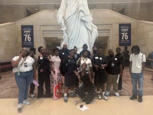 DC3C Summer Pathways student participants and staff pose in front of a statue in a government building